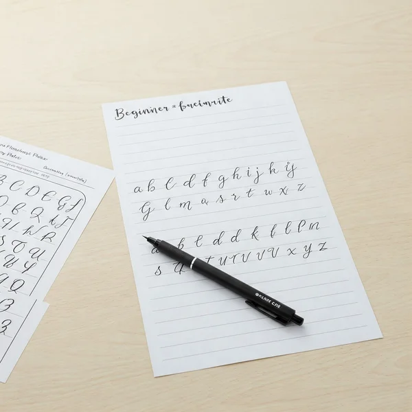 Essential cursive writing tools for beginners on desk