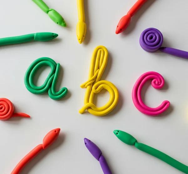Colorful Play-Doh formed into cursive letters on a table